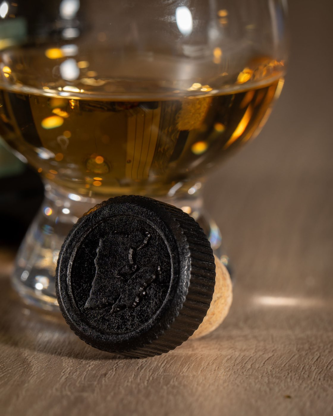 The Bunnahabhain Stiùireadair bottle stopper in front of a glass of whisky