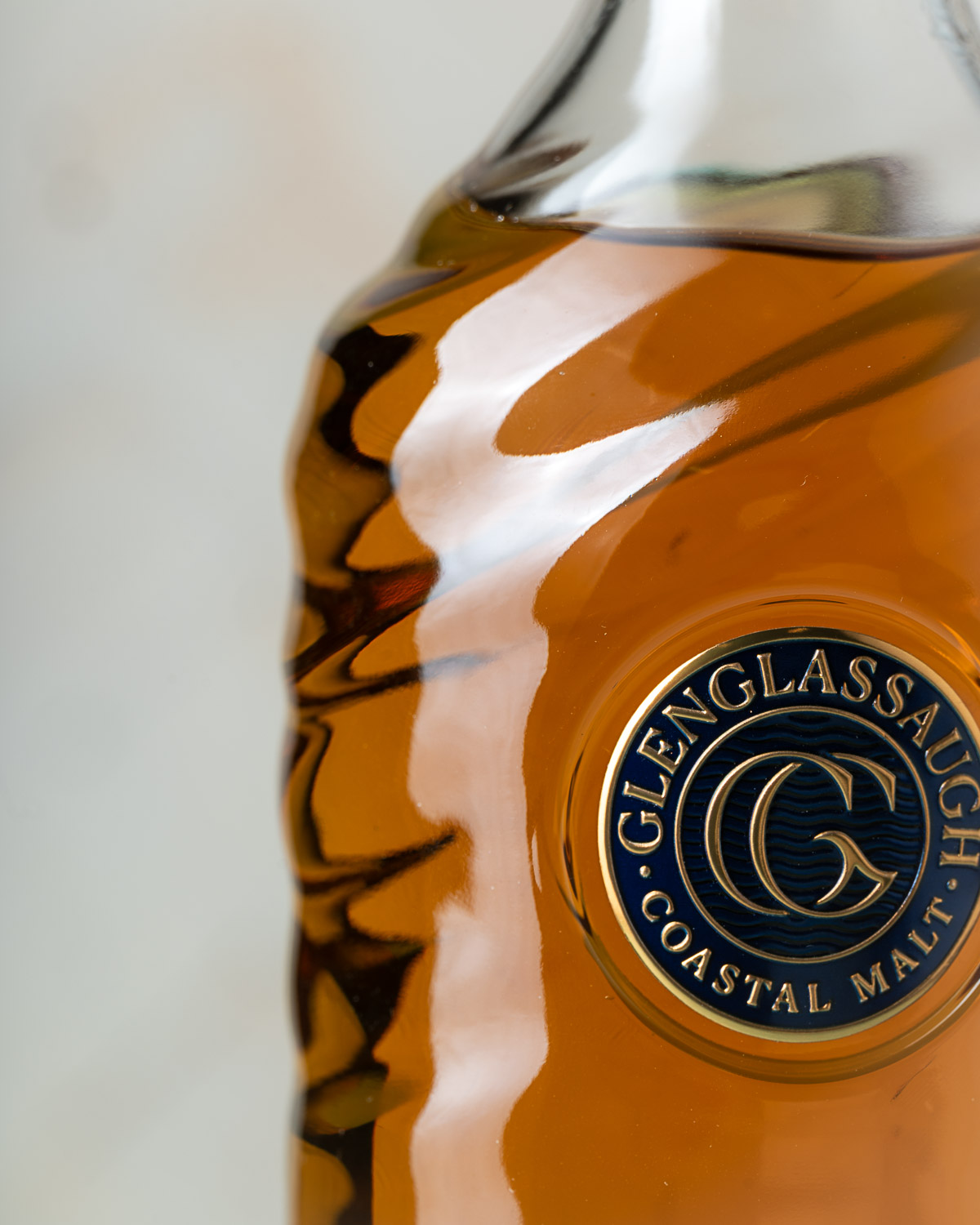 Close-up of the spiral-twist bottle shoulder and the navy and gold Glenglassaugh medallion