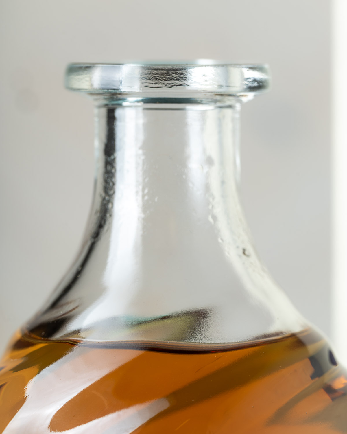Close-up of the clear glass bottle neck showing the spiral twist in the glass