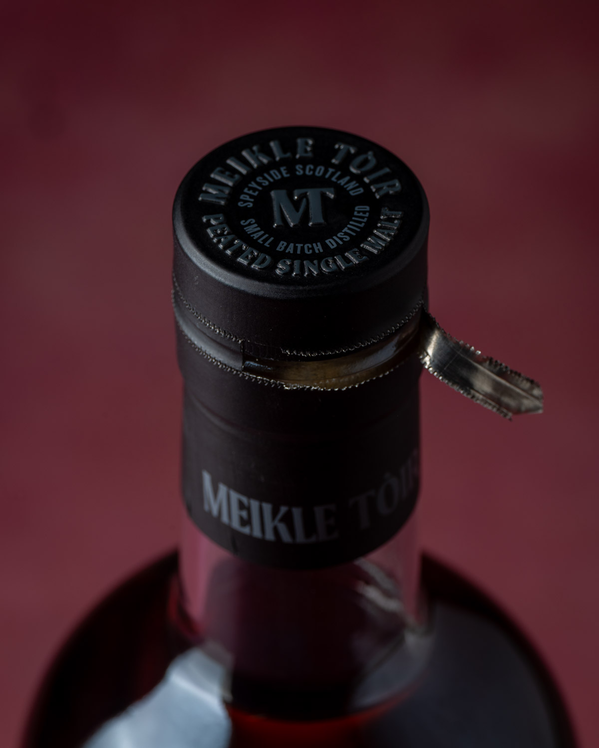 Close-up of the bottle's tamper-evident capsule and pull tab